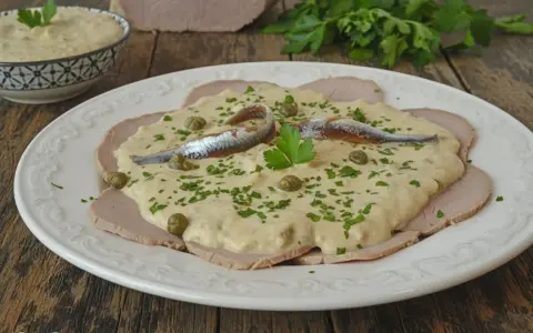 Vitello tonnato veloce: fettine di arrosto di vitello con salsa tonnata, capperi, acciughe e prezzemolo tritato.