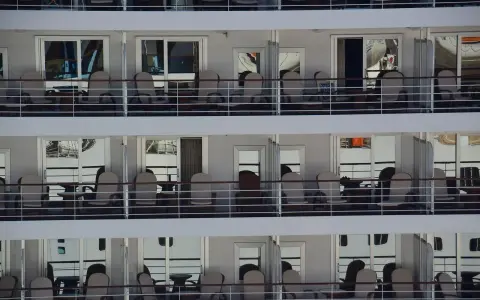 File di cabine crociera con balconi arredati con sedie e tavolini, pronte per accogliere i passeggeri.