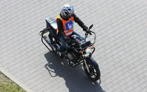Motocyklista w kamizelce z literą "L" na placu manewrowym. Czy to nauka jazdy na motorze o pojemności 250cc, by zdobyć a2 prawo jazdy?