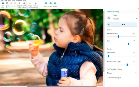 Dziewczynka dmucha bańki. Program Easy Photo Unblur pomaga jak wyostrzyć zdjęcie, oferując opcje redukcji rozmycia i poprawy detali.