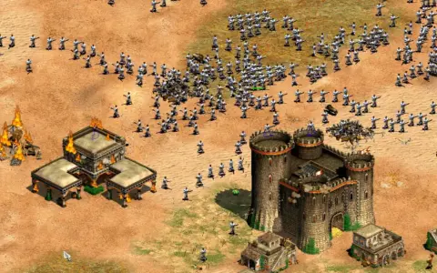 Un ejército avanza en Age of Empires 3, con edificios en llamas y un castillo imponente. ¡Descubre trucos para dominar el campo de batalla!