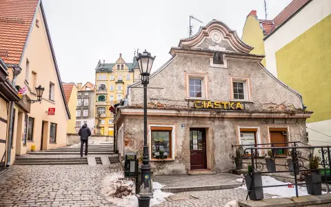 Kłodzko rynek. Kamienne uliczki i kolorowe kamienice tworzą urokliwy klimat. Na pierwszym planie budynek z napisem "Ciastka".