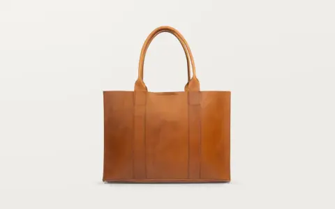 Brązowa, skórzana torebka typu shopper. Dowiedz się, jak wyczyścić skórzaną torebkę domowym sposobem, by wyglądała jak nowa.