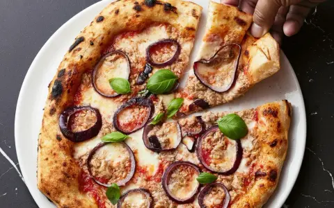 Italienisches Thunfisch Pizza Rezept: knuspriger Teig, Tomaten, Mozzarella, Thunfisch, rote Zwiebeln und Basilikum.