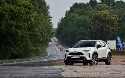 Biały crossover na poboczu drogi, w tle sznur samochodów i zielone drzewa. Trasa z Warszawy do Szczecina, ile km?