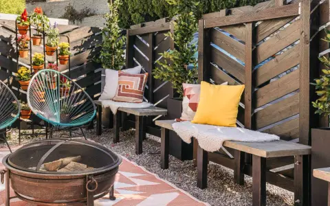 A cozy patio with a diy privacy screen, fire pit, and colorful chairs.