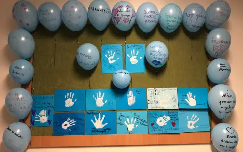 Dzień dziecka w szkole: niebieskie balony z napisami o prawach dzieci i rysunki dłoni.