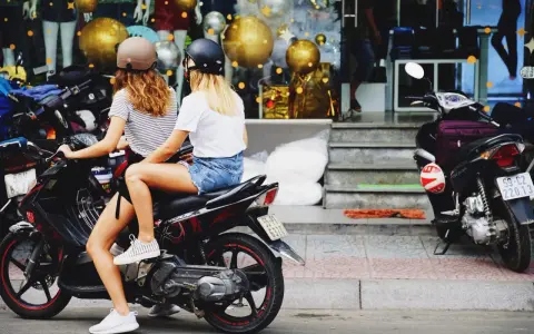 Dos chicas con cascos en una moto, listas para sacar carnet moto y disfrutar de la libertad.
