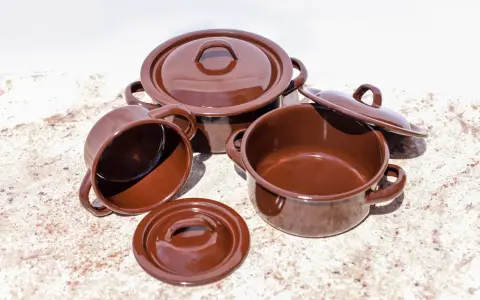 Conjunto de cazuelas de barro esmaltada en marrón. Listas para curar y preparar deliciosos guisos.