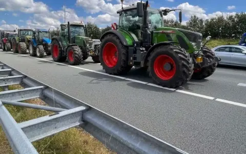 Una fila di trattori attraversa un'autostrada, un'immagine che ricorda che sulle autostrade e strade extraurbane principali è vietata la circolazione di macchine agricole.