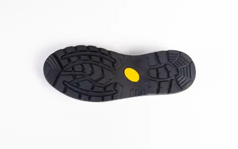 Czarna podeszwa buta z żółtym logo Vibram, gotowa do wymiany w butach, zapewniająca przyczepność.