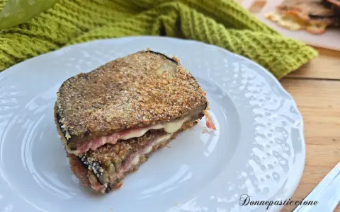 Un goloso cordon bleu di melanzane, impanato e fritto, con un cuore filante di formaggio e prosciutto.