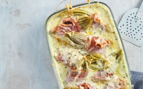 Überbackener Chicorée mit Schinken in cremiger Sauce, ein köstliches Gericht, das Lust auf mehr Chicorée-Rezepte macht.