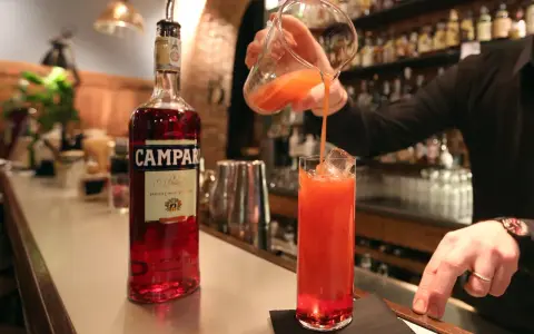 Barman nalewa drink z Campari do szklanki. Aperol kontra Campari - wybór należy do Ciebie!