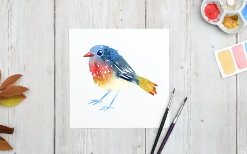 Un charmant dessin oiseau aquarelle aux couleurs vives, posé sur du papier blanc. Des feuilles d'automne et du matériel de peinture complètent la scène.