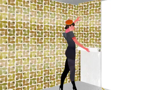 Mujer con boina naranja y vestido gris, aplicando papel pintado con patrón de olivas. Aprende como rematar papel pintado para un acabado perfecto.
