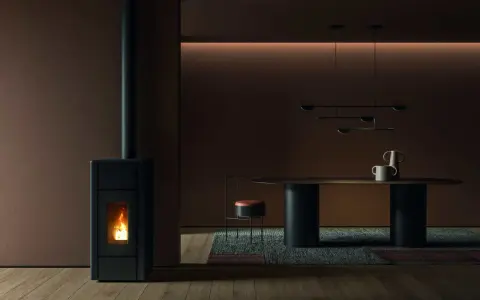 Un poêle à granulés dégage une douce chaleur, la flamme danse dans la chambre de combustion. La température ambiante est agréable, la fumée s'échappe par la cheminée.