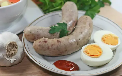 Biała kiełbasa z jajkiem i ketchupem, obok czosnek i natka. Idealne dodatki, jakie przyprawy do białej kiełbasy?