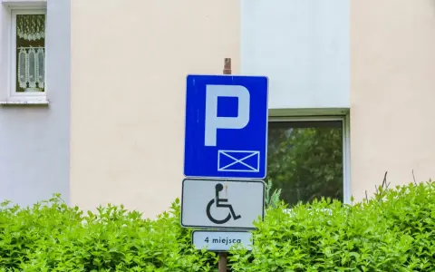 Znak parkingowy dla osób z niepełnosprawnościami, wskazujący 4 miejsca. Informuje o udogodnieniach dla osób z różnymi stopniami niepełnosprawności.