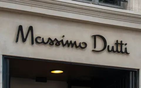 Elegancki szyld Massimo Dutti nad wejściem do sklepu. Planujesz Massimo Dutti zwroty? Sprawdź ofertę!