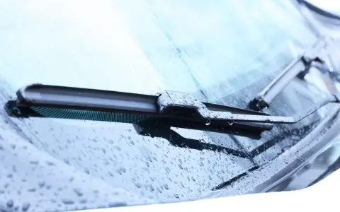 Scheibenwischer mit Wassertropfen. Die Scheibenwaschanlage funktioniert nicht. Woran kann das liegen? Vielleicht ist die Düse verstopft oder die Pumpe defekt.