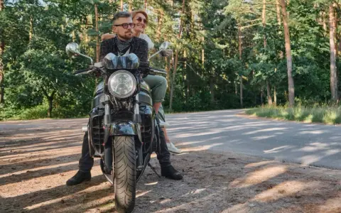 Para wyrusza na motocyklu przez las, marząc o podróży przez Karpaty i Sudety.