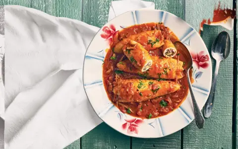 Assiette de calamars farcis à la sauce tomate, une recette encornet tomate savoureuse, garnie de persil frais.