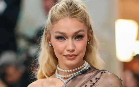 Gigi Hadid luce un maquillaje con perlas, con pequeños adornos brillantes en los ojos y un collar de perlas.