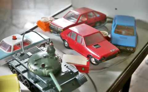 Kolekcja **polskich zabawek**: czołg, radiowóz, czerwony Fiat i niebieski samochód.