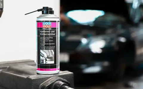 Puszka preparatu do czyszczenia wtryskiwaczy Liqui Moly na tle rozmazanego silnika.