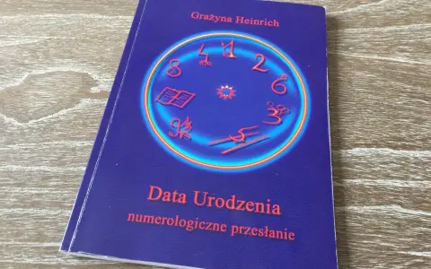 Okładka książki "Data Urodzenia numerologiczne przesłanie" Grażyny Heinrich. Centralny element to okrąg z cyframi i symbolami, sugerujący analizę liczby numerologicznej.