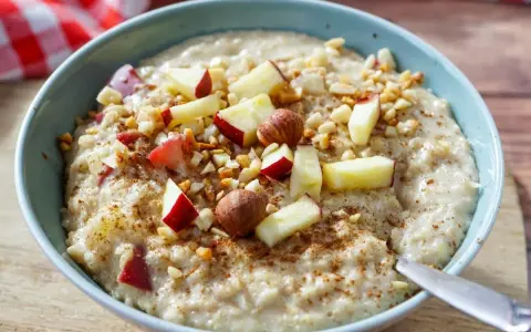 Schmackhaftes Porridge selber machen mit Apfelstücken, Nüssen und Zimt bestreut. Ein gesunder Start in den Tag.