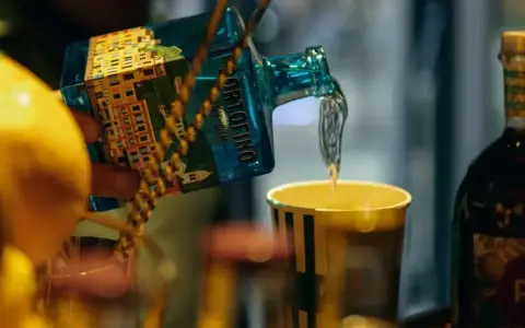 Barmistrz nalewa gin z butelki Portofino do szklanki, przygotowując drinka. Ciekawi Cię, jak smakuje martini?