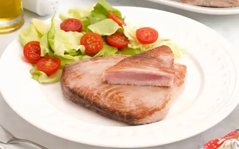 Delicioso atún a la plancha con ensalada fresca de lechuga y tomates cherry. Un plato ligero y saludable.