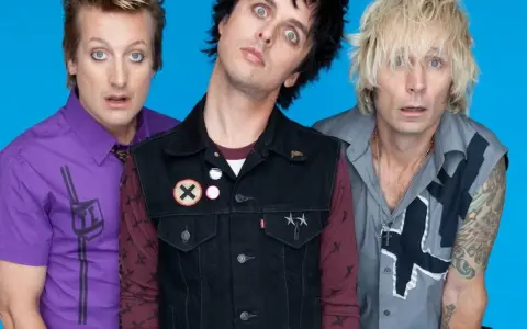 Trzech członków zespołu Green Day Polska z wyrazistymi minami na niebieskim tle.