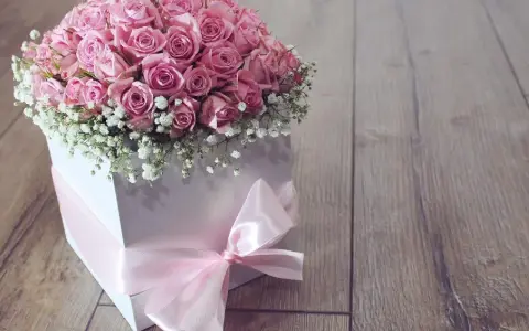 Piękne różowe róże w białym pudełku z różową wstążką. Idealne na prezent, pokazują, jak zrobić pudełko do flower box.