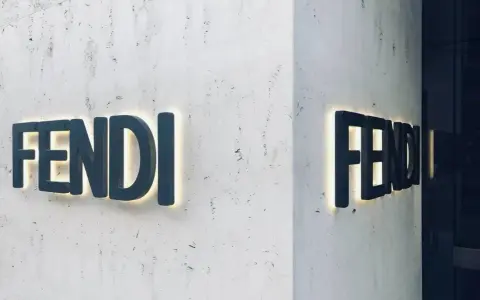 Insegna luminosa Fendi su una parete di marmo. Il **Fendi significato** è lusso e artigianalità italiana.