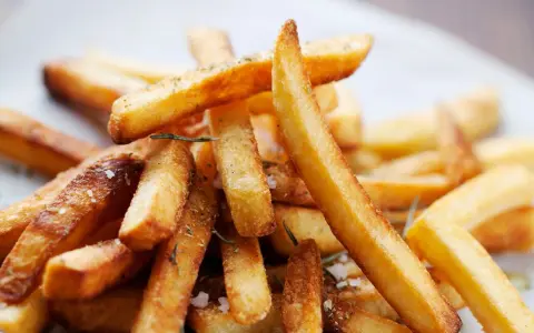 En hög med gyllene, krispiga pommes frites, strödda med örter och havssalt. Perfekt för en mysig hemmakväll.