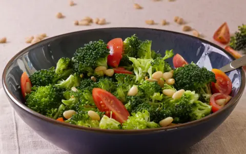 Frischer Brokkolisalat mit Tomaten und Pinienkernen. Ja, man kann Brokkoli roh essen, und er schmeckt so am besten!