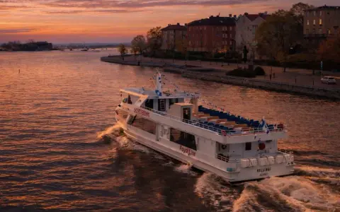 Prom Royal Line "Helsinki" płynie po wodzie podczas zachodu słońca, tworząc fale.