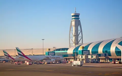 Emiraty Arabskie linie lotnicze na lotnisku w Dubaju. Samoloty Emirates, wieża kontroli lotów i nowoczesny terminal.