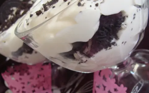 Pyszne deserki z kremem i pokruszonymi oreo ciastkami w szklanych pucharkach.
