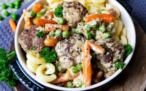 Herzhafte Frikadellen in cremiger Soße mit Erbsen und Möhren, dazu Nudeln. Ein leckeres Wikingertopf Rezept für die ganze Familie.