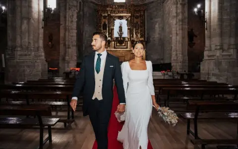 Novios sonriendo y caminando por el pasillo de una iglesia, listos para sus votos matrimoniales divertidos.