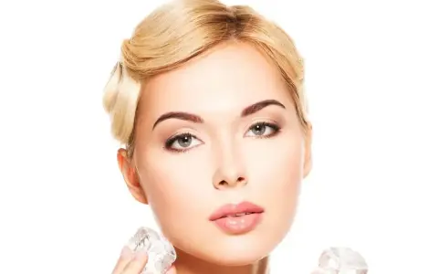 Kobieta z blond włosami stosuje lód na pryszcze, aby uzyskać gładką cerę.