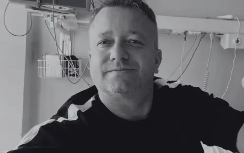 Uśmiechnięty mężczyzna w szpitalnym łóżku, słuchający dj hazel utwory.