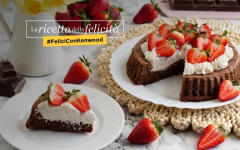 Una crostata morbida al cioccolato, guarnita con panna e fragole fresche, è la ricetta della felicità.