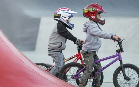 Dwóch chłopców w kaskach na rowerach BMX gotowych do zjazdu. Idealne rzeszów atrakcje dla dzieci do aktywnego spędzania czasu.