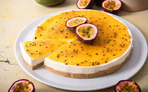 Ein cremiger Maracuja Cheesecake mit leuchtend gelbem Topping und frischen Passionsfrüchten.