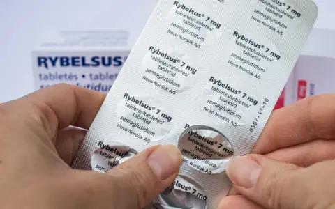 Dłonie trzymają opakowanie leku Rybelsus 7 mg. Cena Rybelsus jest ważnym czynnikiem dla pacjentów.